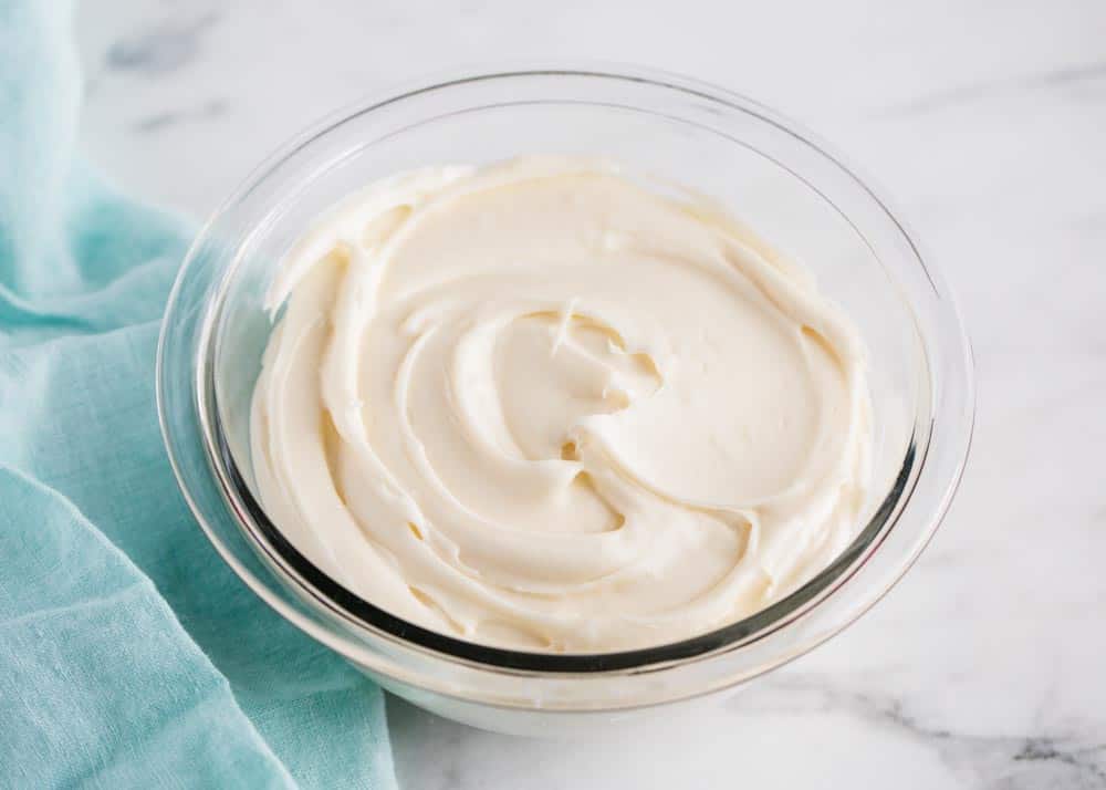 Cream cheese frosting in a glass bowl.