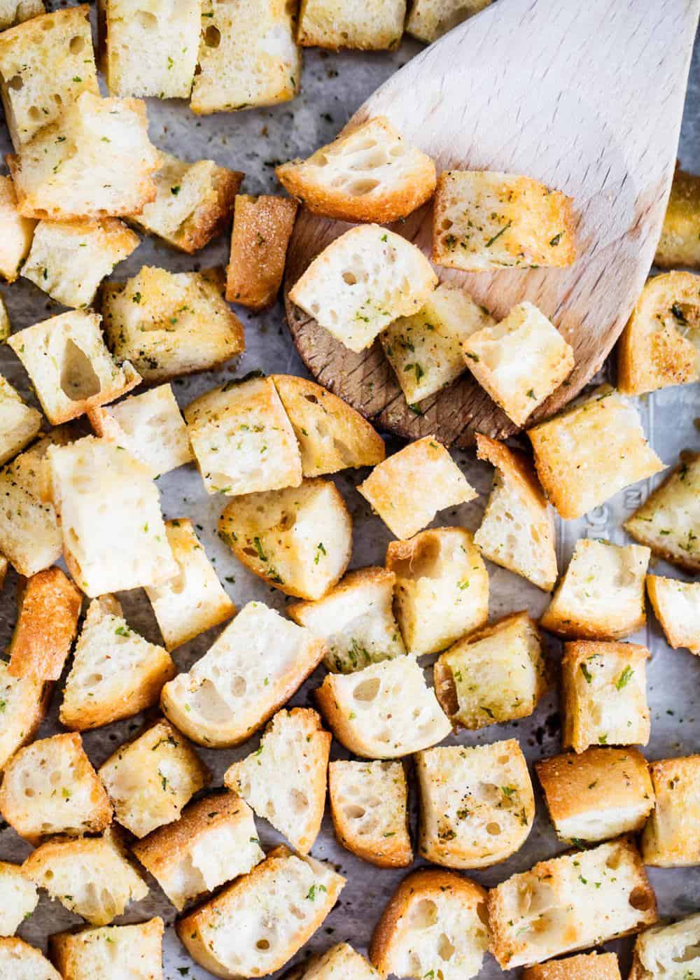 Croutons baked on a pan with wooden spoon.