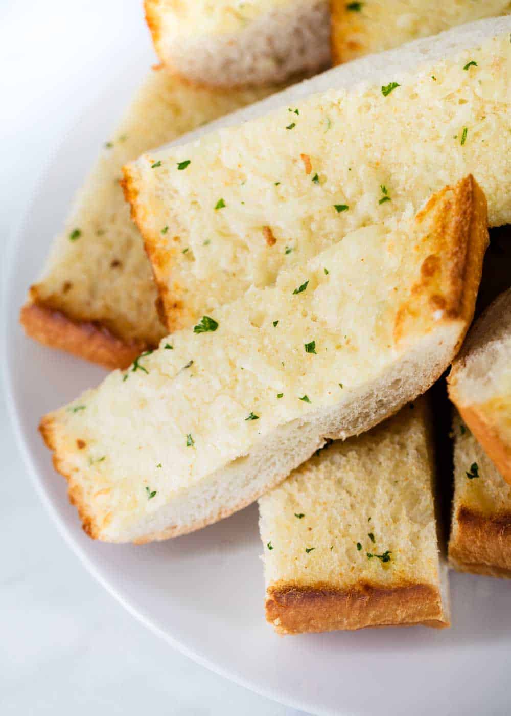 Close up of sliced garlic bread on plate.