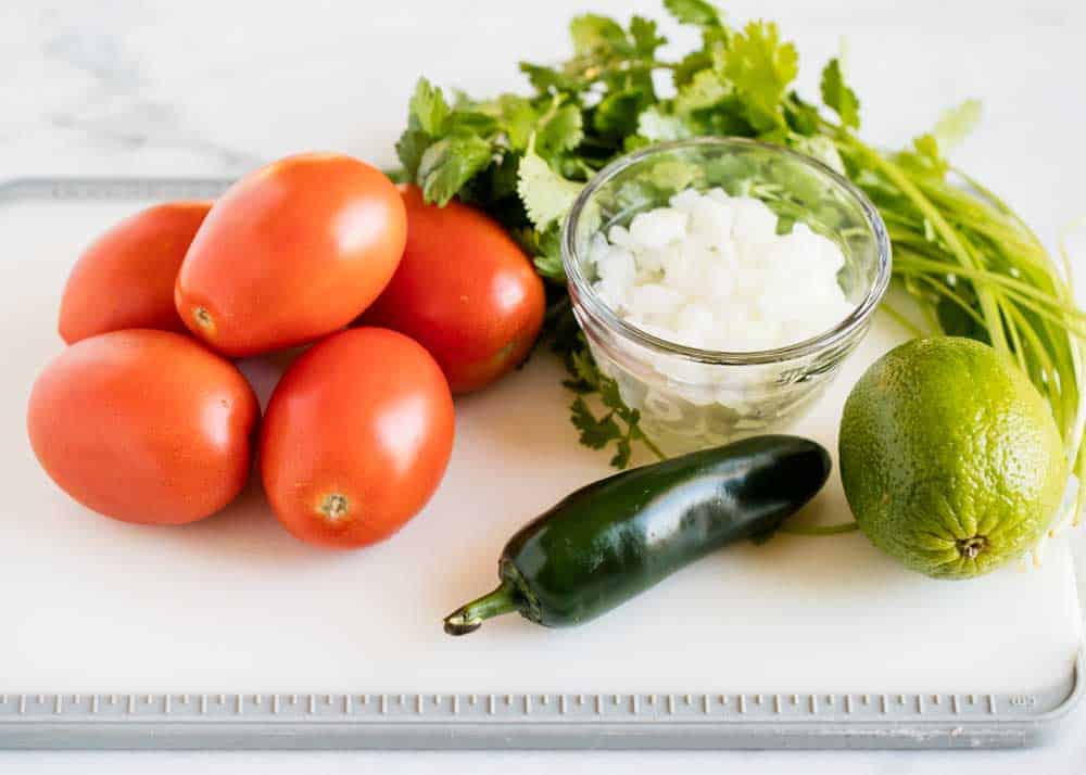 Pico de gallo ingredients on cutting board.