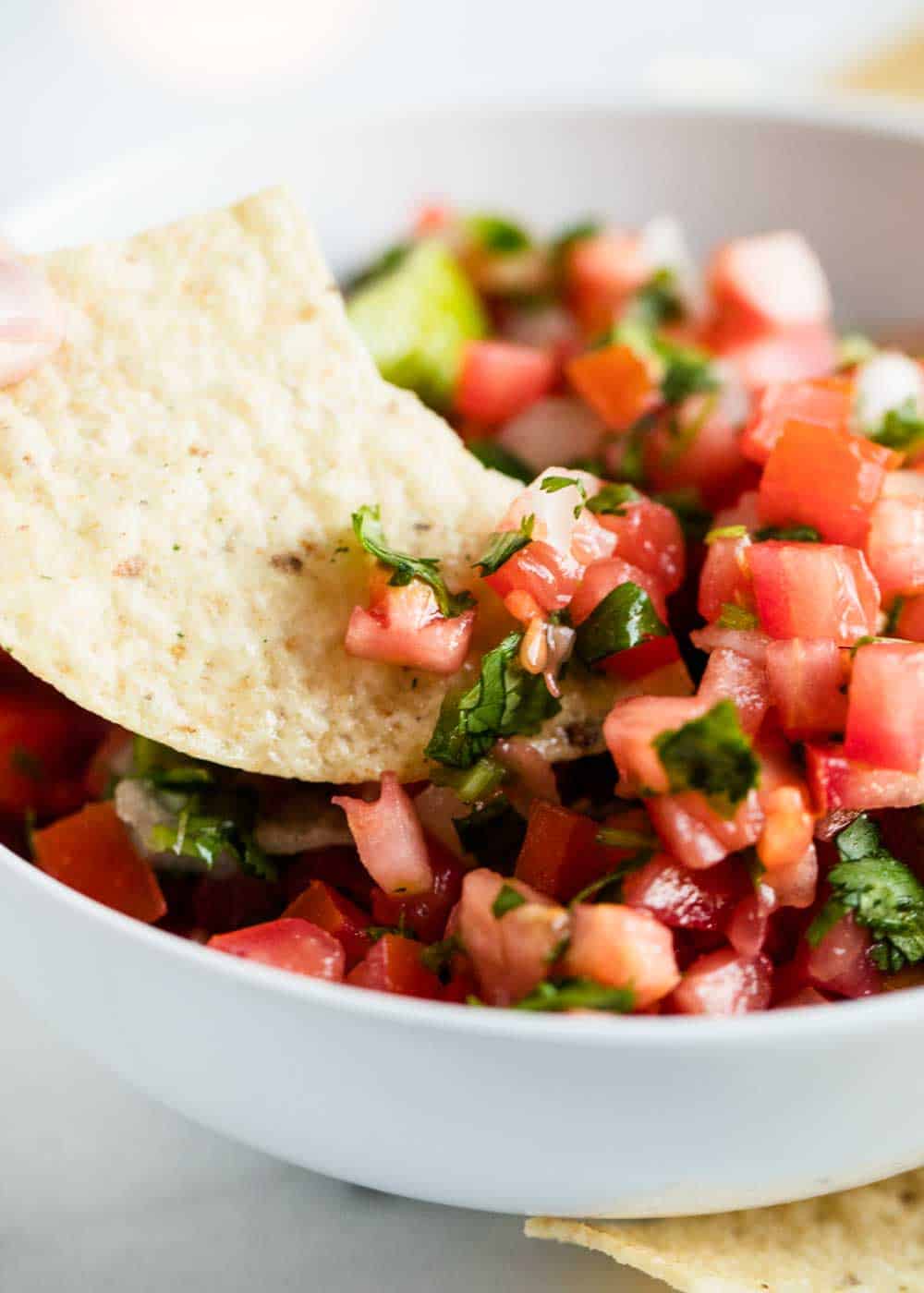 Dipping tortilla chip in pico de gallo.