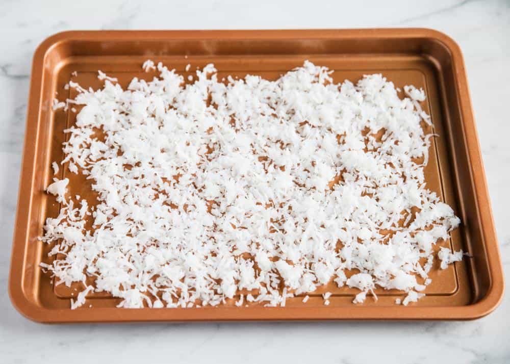 Toasting coconut flakes on pan.