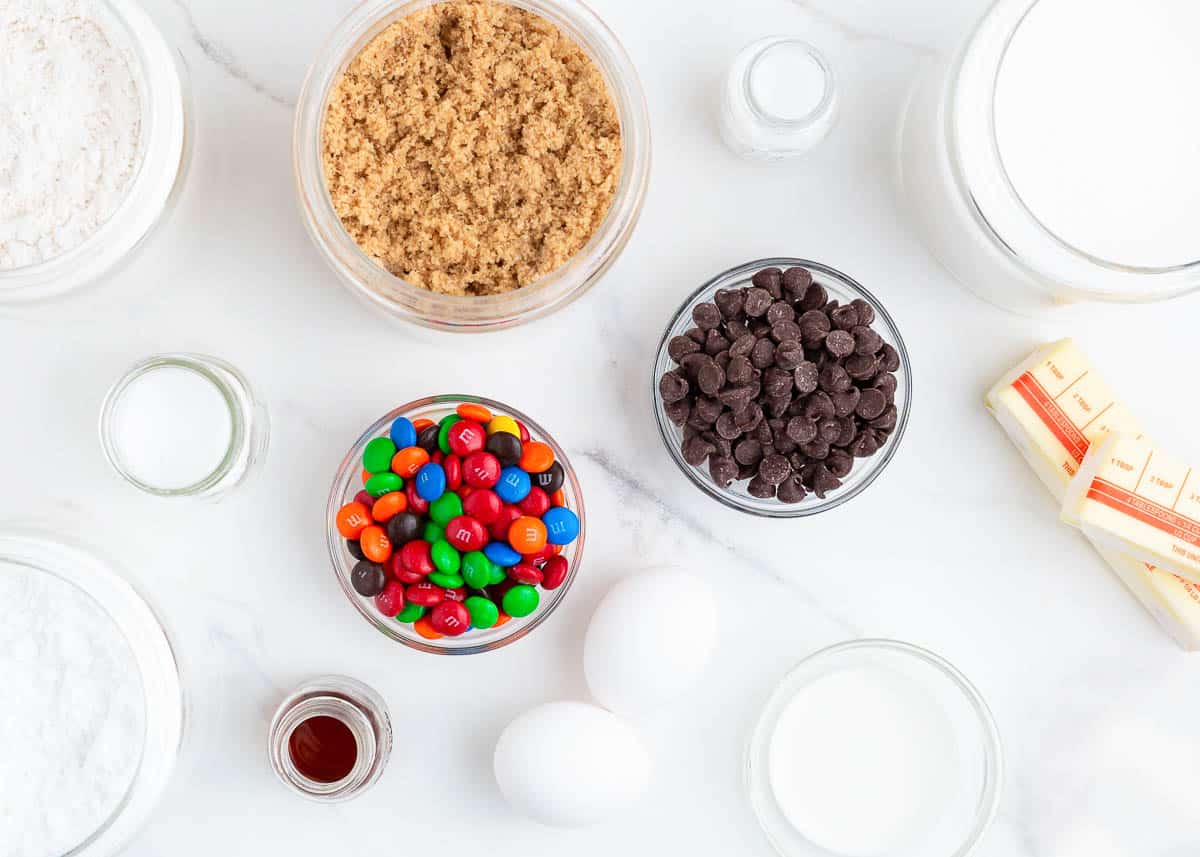 M&M cookie ingredients on marble counter. 