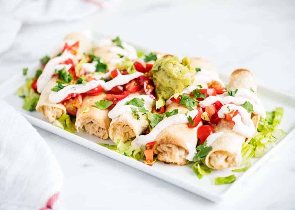 Baked chicken taquitos on plate.