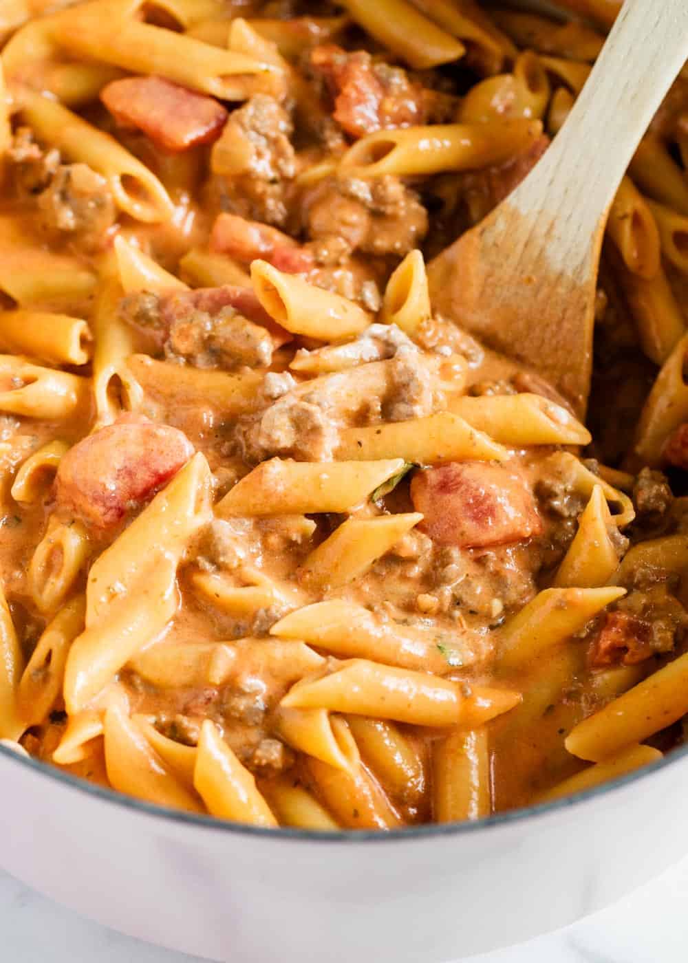 Ziti pasta in pot with wooden spoon.