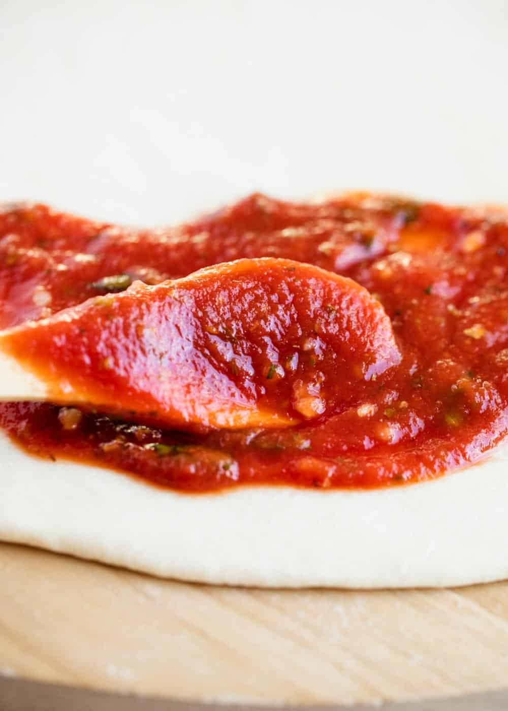 Pizza sauce spread on pizza dough.