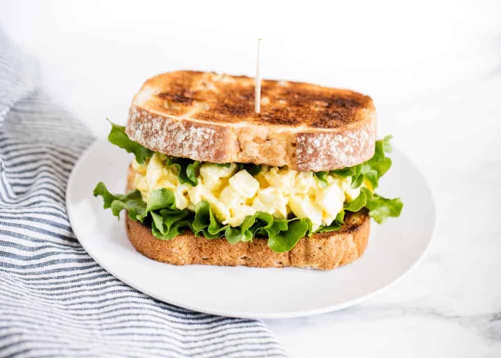 Egg salad sandwich on plate.