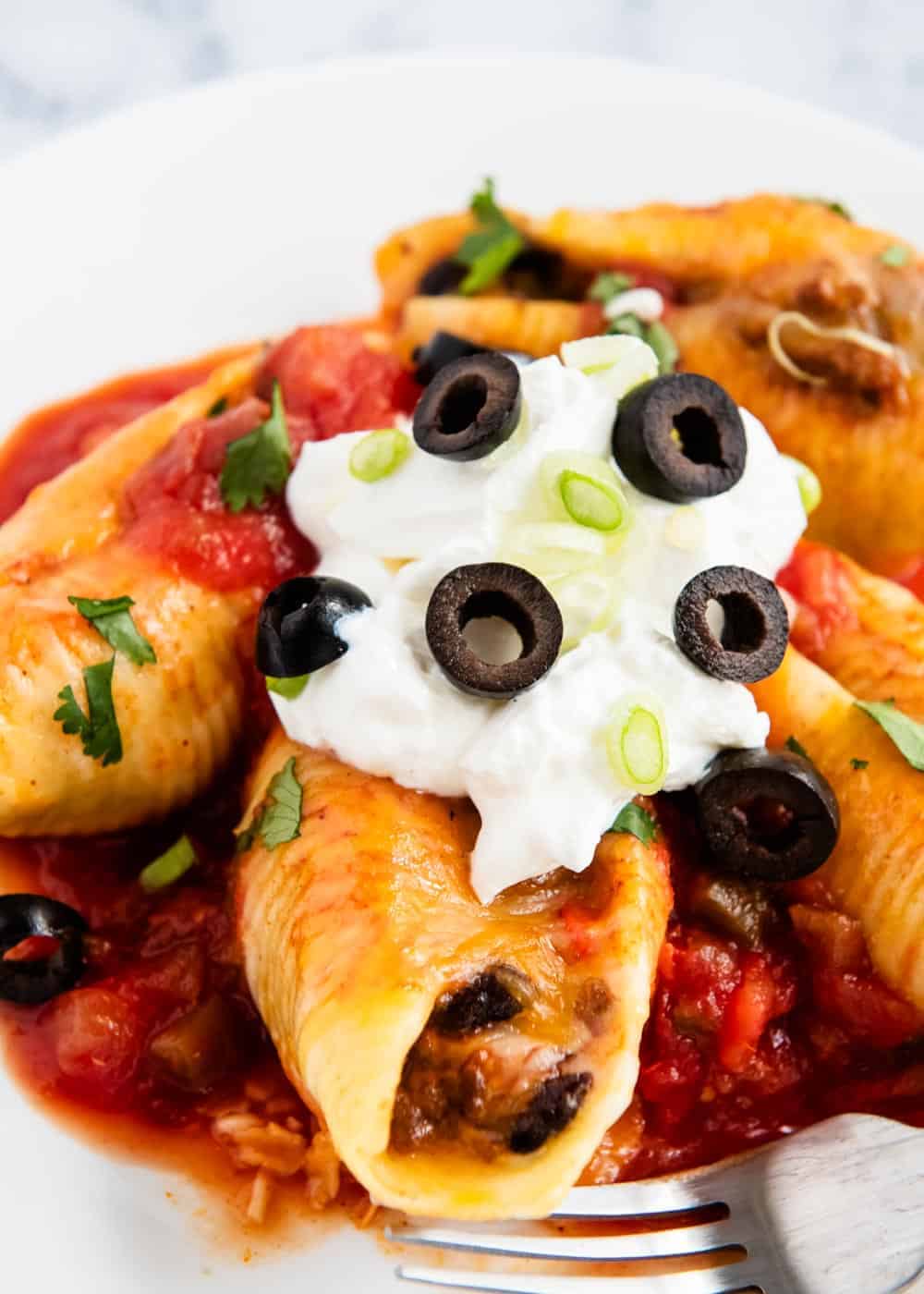 Close up of Mexican stuffed shells with toppings.