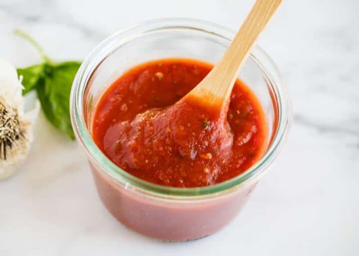 pizza sauce in jar with wooden spoon 