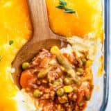 Shepherd's pie being dished out of a casserole dish.