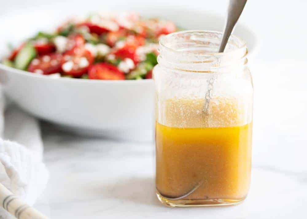 The perfect easy vinaigrette dressing for your everyday salads that comes together in less than 5 minutes! This homemade dressing is so simple to make with the best sweet and savory flavor that you'll never purchase store-bought again! Vinaigrette in jar with spoon.