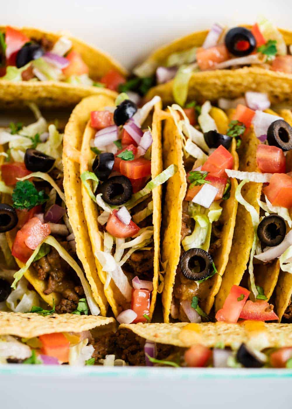Close up of ground beef tacos with toppings.