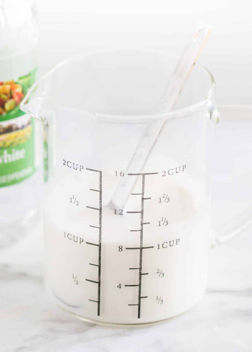 Close up of homemade buttermilk in measuring cup.