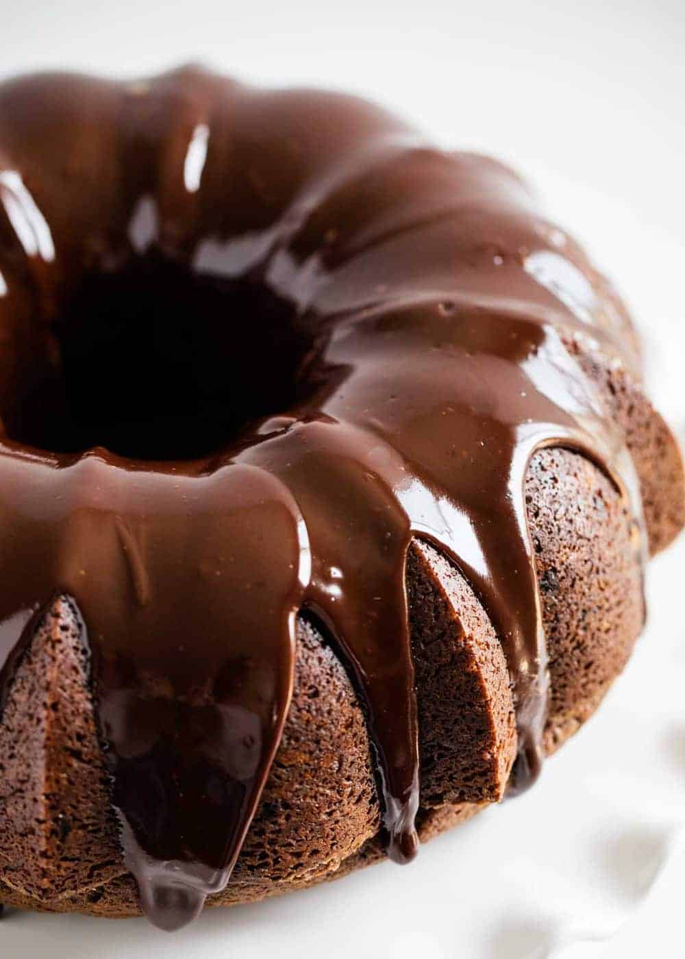 Chocolate bundt cake on white cake stand.