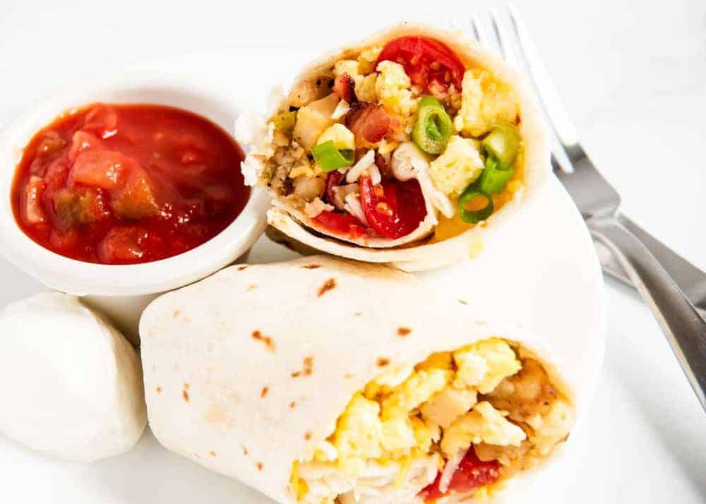 Easy breakfast burritos on a white plate.