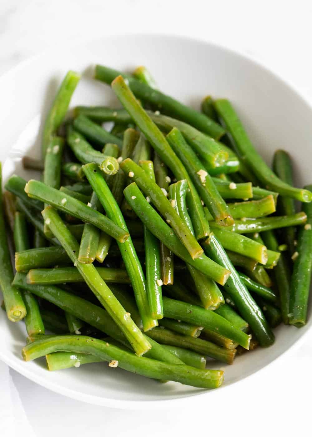 Close up of a bowl of cooked green beans.