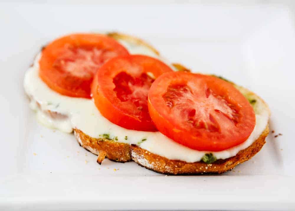 Open faced grilled caprese sandwich.