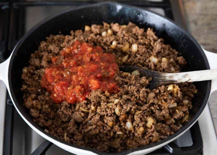 mixing salsa into a pan of taco meat 