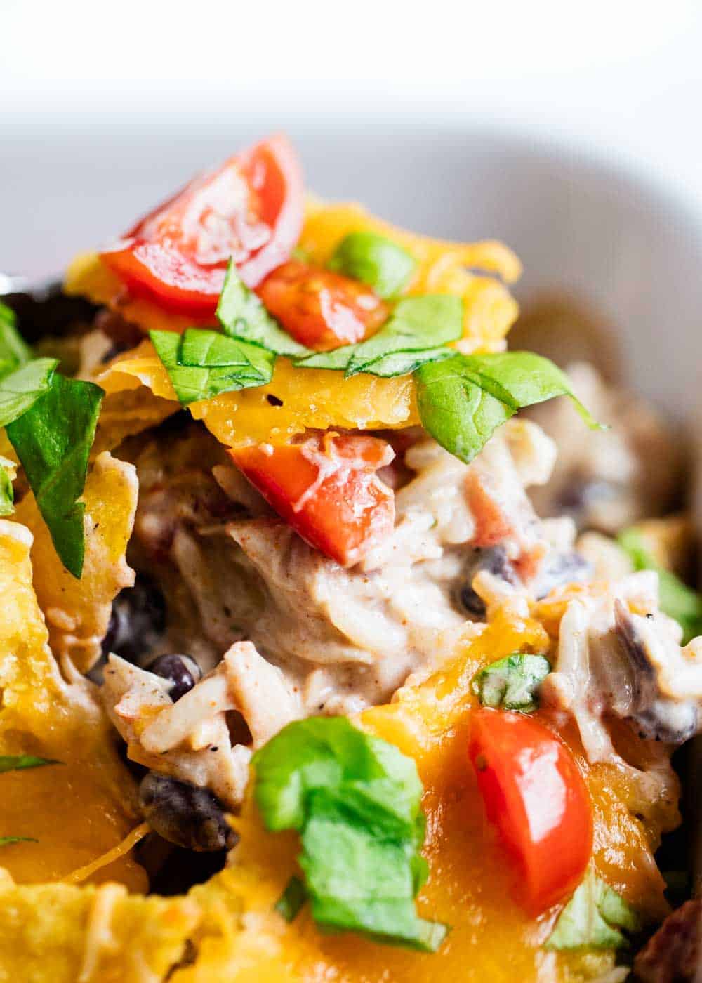 Scooping Mexican chicken casserole from baking dish.