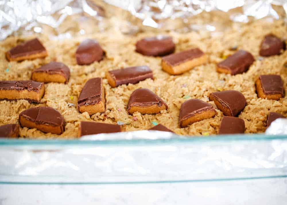 Reese's Peanut Butter Blondies topped with M&M's and stuffed with chocolate goodness! This blondie dessert is a fun twist on the traditional blondies and makes the perfect Easter treat! peanut butter blondie recipe