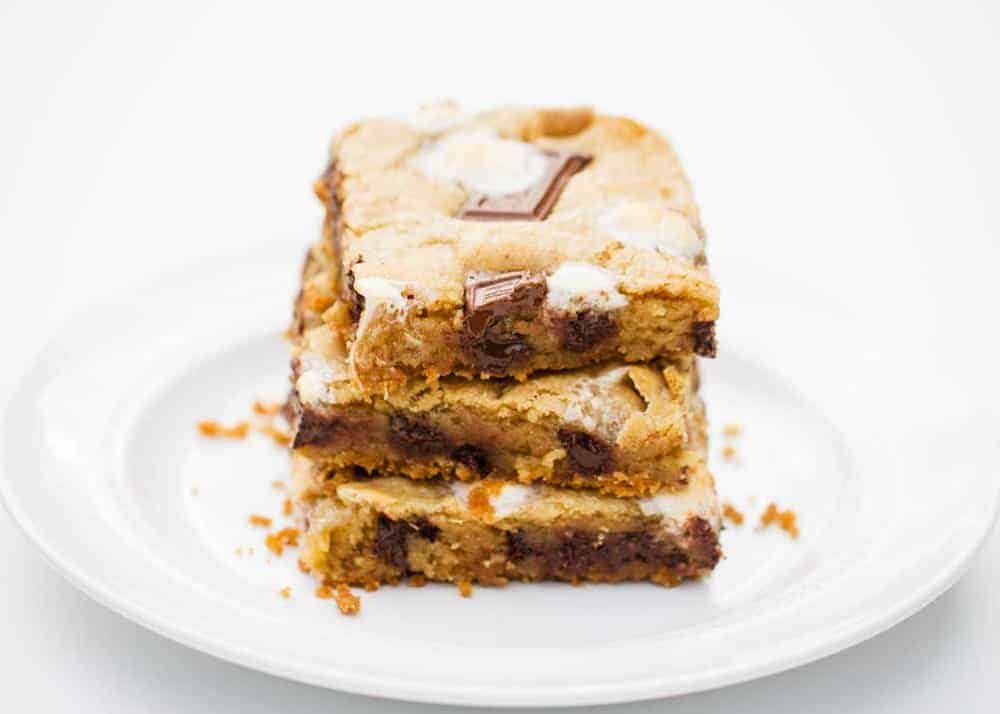 Three s'mores bars stacked on a plate.