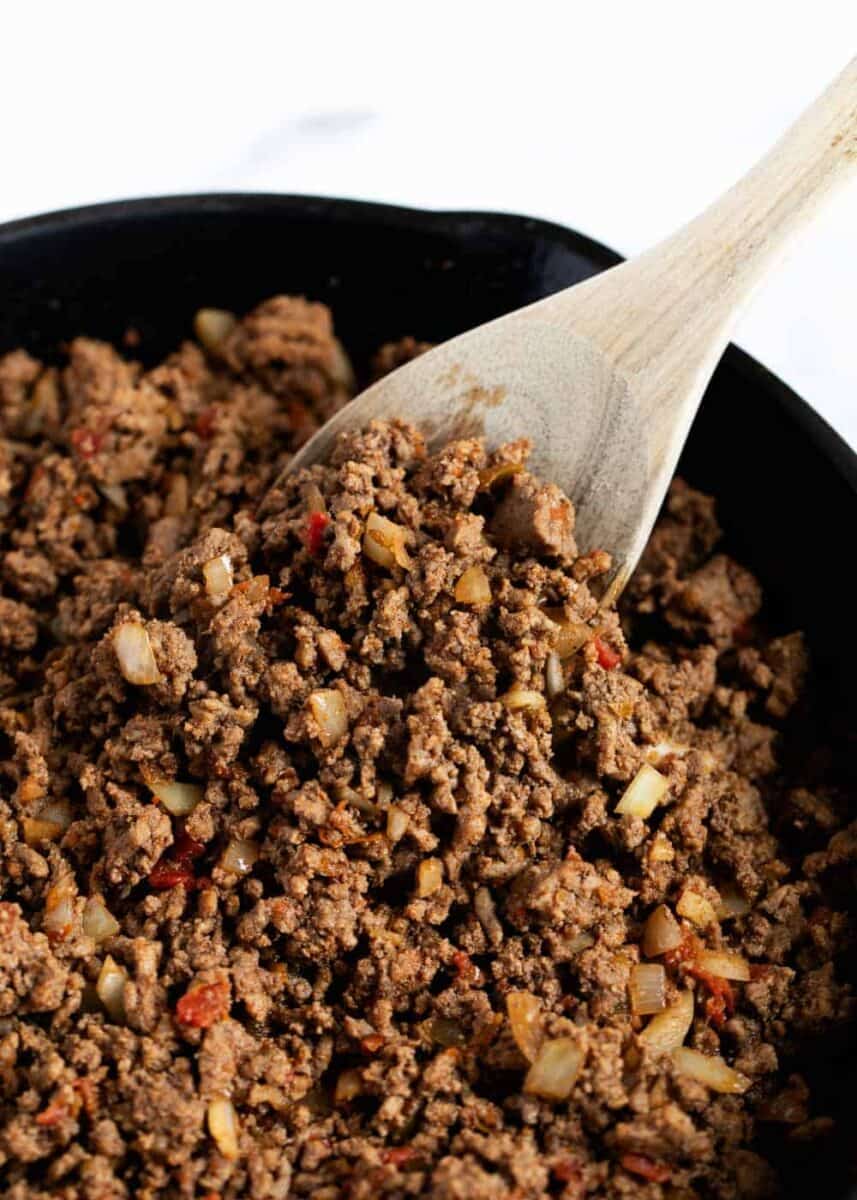 taco meat in pan with wooden spoon 