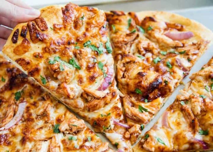 lifting up a slice of barbecue chicken pizza
