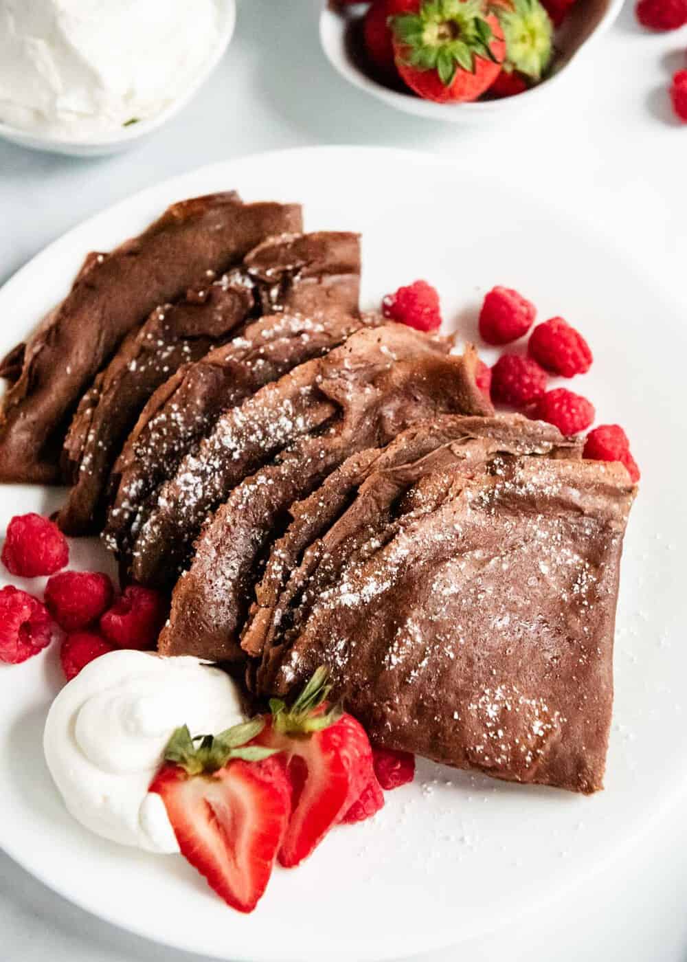 Chocolate crepes on white plate.