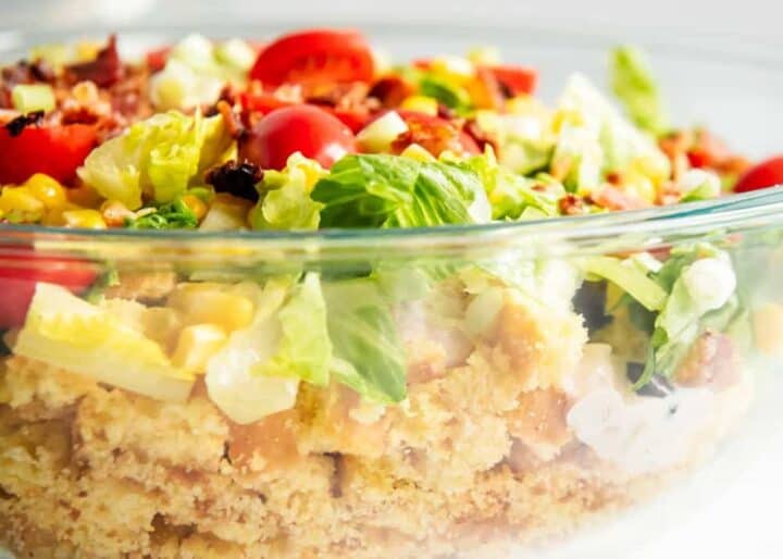 layered cornbread salad in a glass bowl 