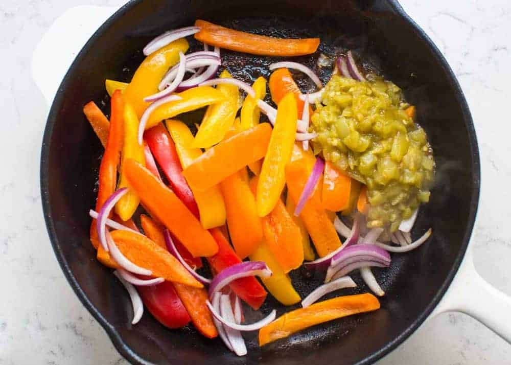 Fajita vegetables cooking in skillet.