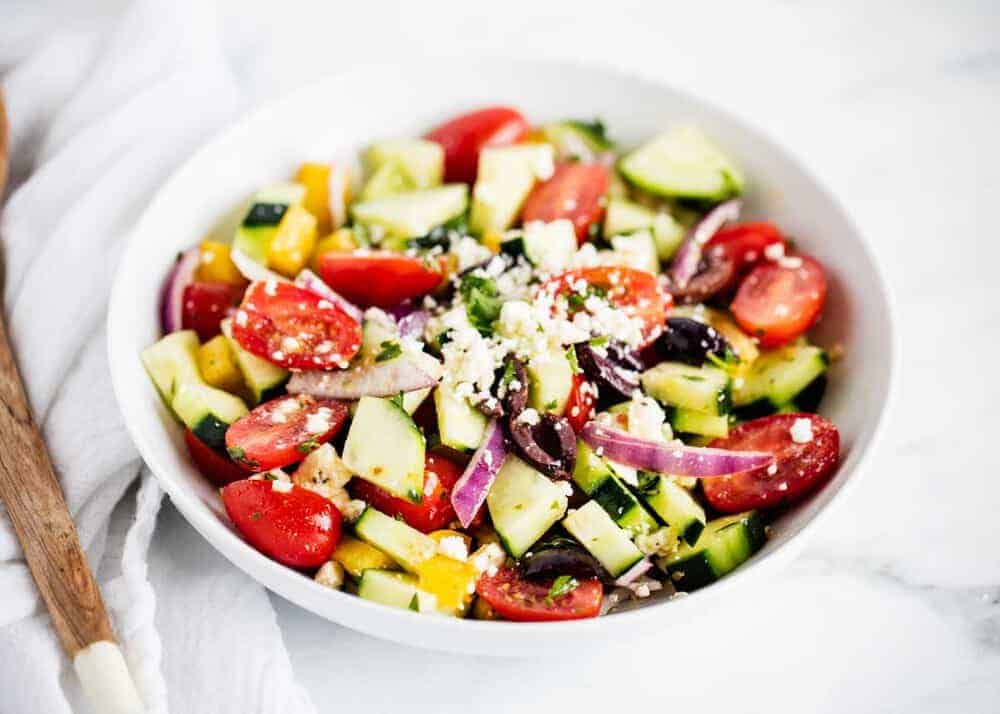 Greek salad in a white bowl.