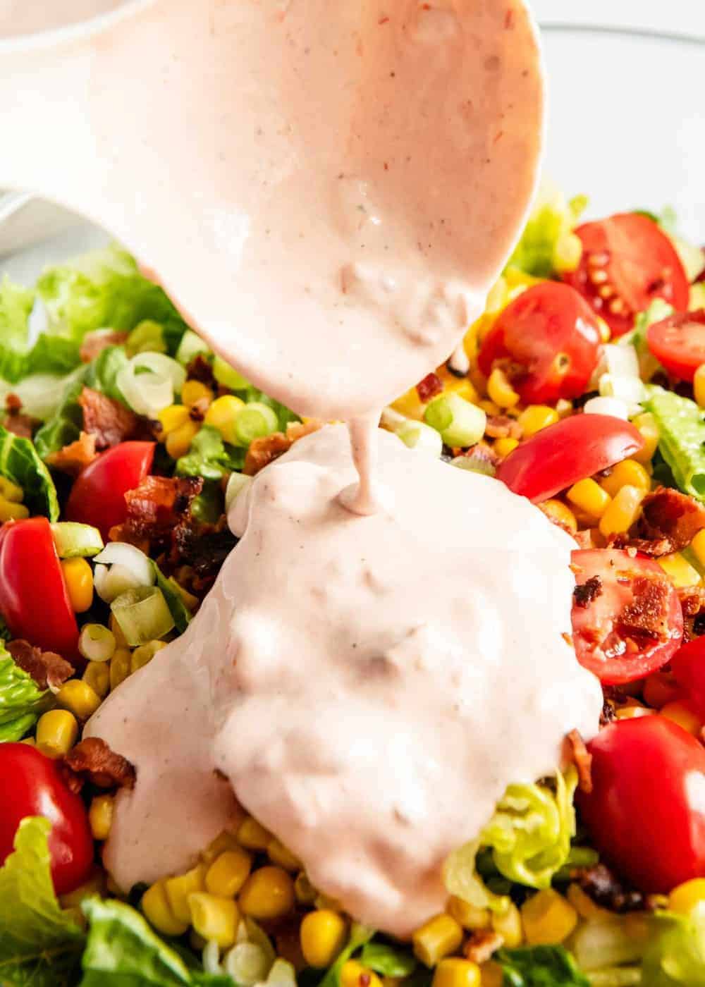 Pouring dressing on top of cornbread salad.