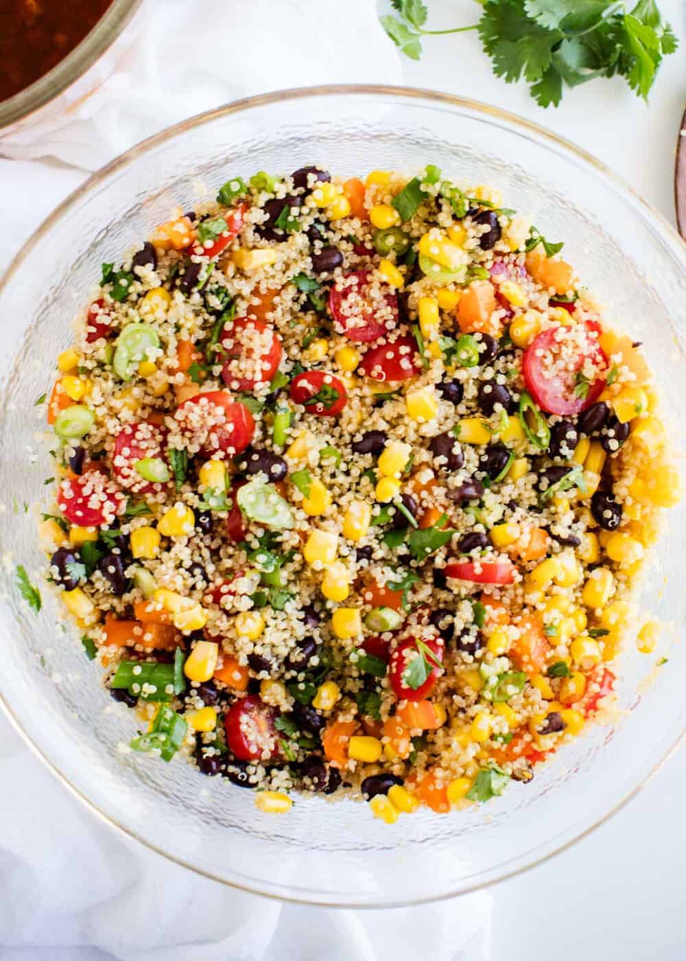 This southwest quinoa salad makes a delicious and flavorful side dish or main meal. You can feel great about eating this healthy, protein-packed quinoa salad all summer long! Southwest quinoa salad in a glass bowl.