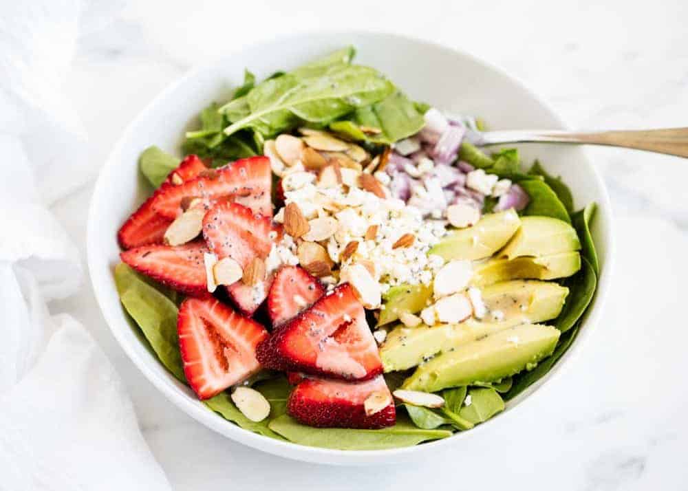 Spinach and strawberry salad in bowl.