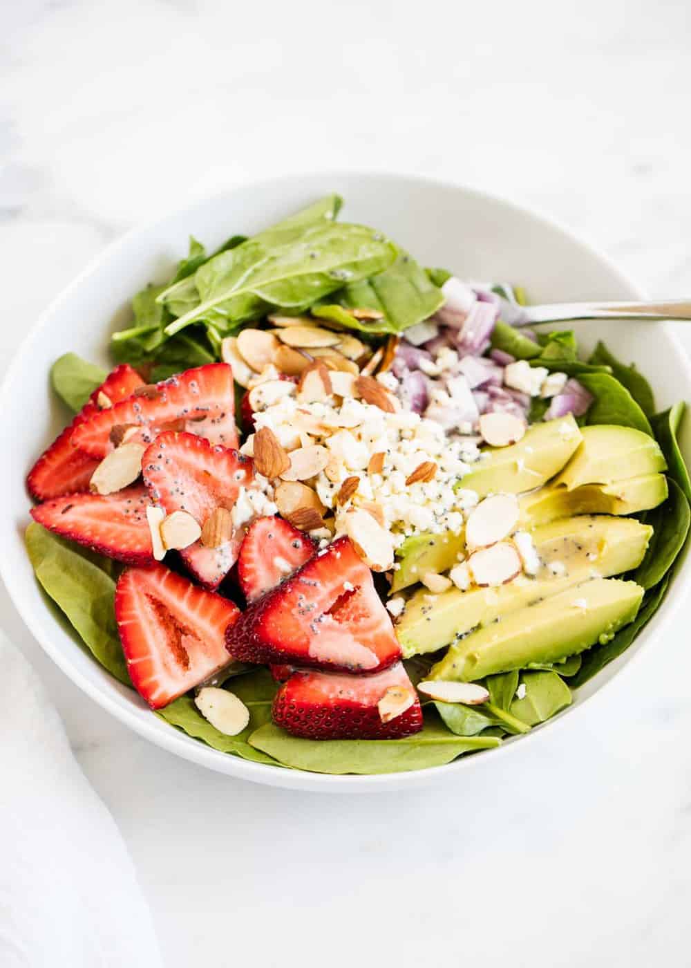 Strawberry spinach salad in a white bowl. 