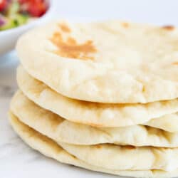 Stacked pita bread on marble.