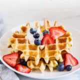 belgian waffle with berries on a white plate