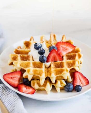 belgian waffle with berries on a white plate
