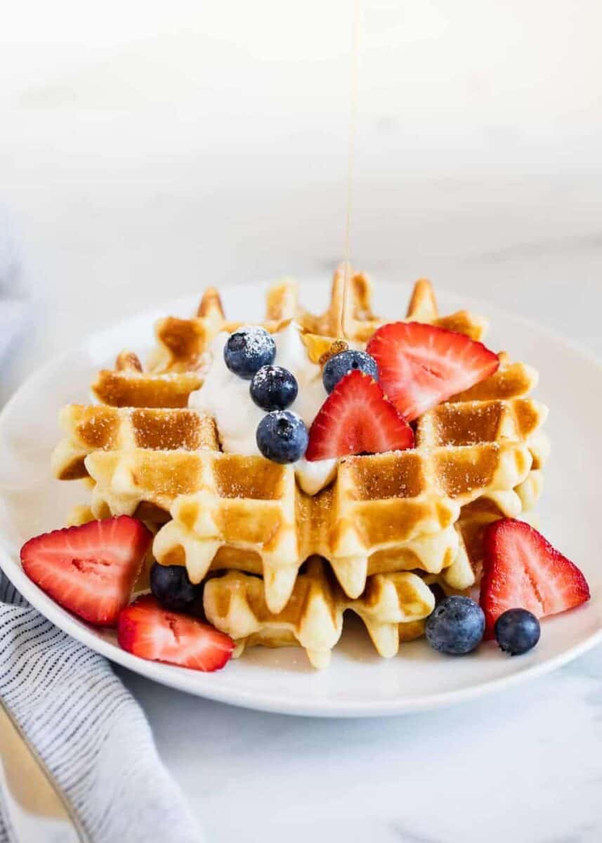 belgian waffle with berries on a white plate