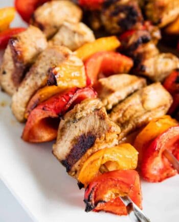 cooked chicken kabobs on white plate