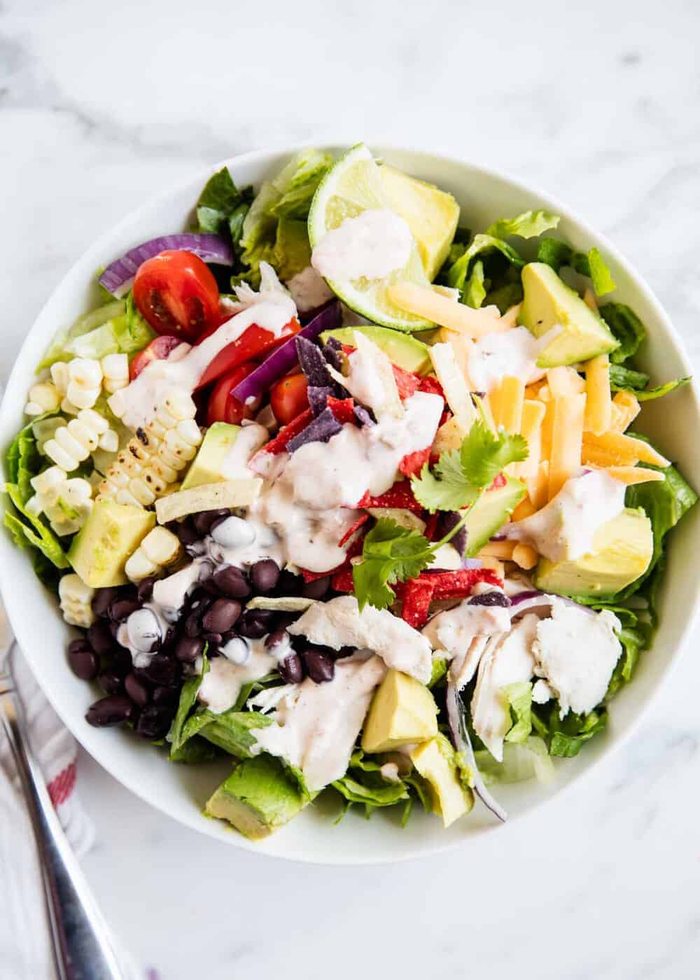 Chicken taco salad in a white bowl.