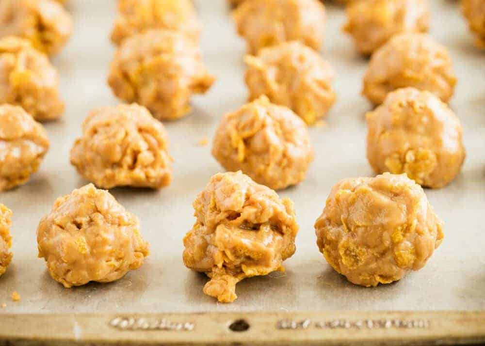 Cornflake peanut butter balls on a baking sheet.