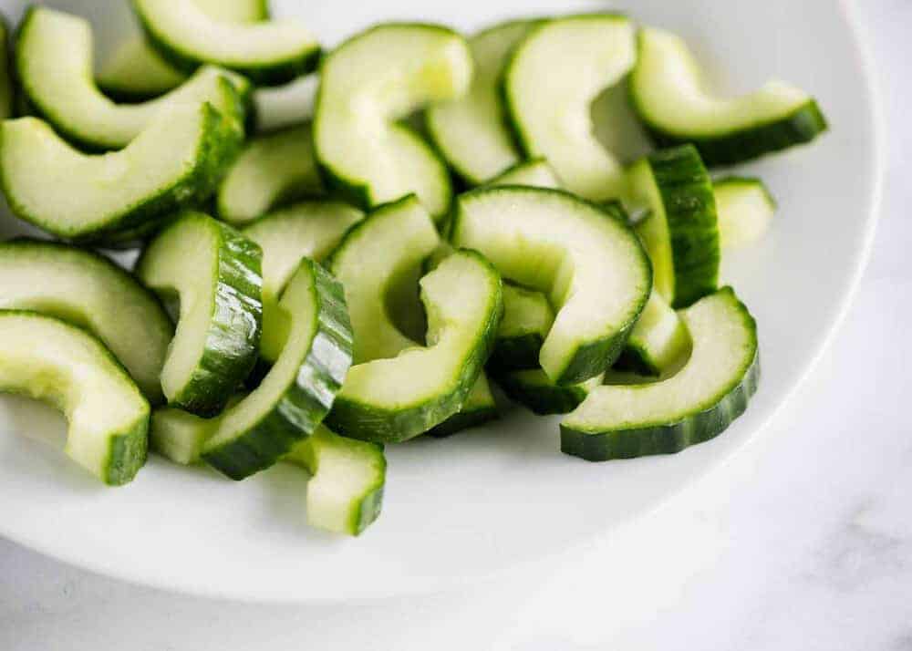 Sliced cucumbers on a white plate.