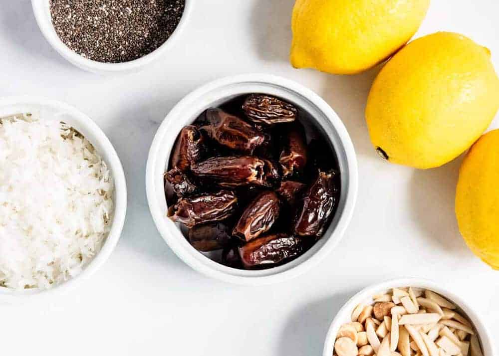 Ingredients for coconut energy balls on a white counter.