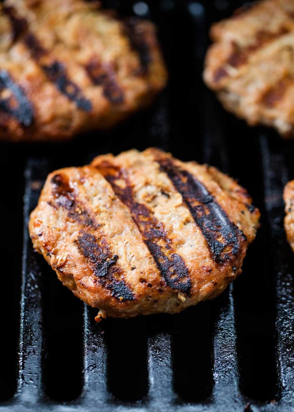 Turkey burgers with grill marks on the grill.