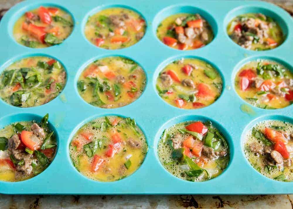 Egg frittata muffins in blue silicone muffin pan.