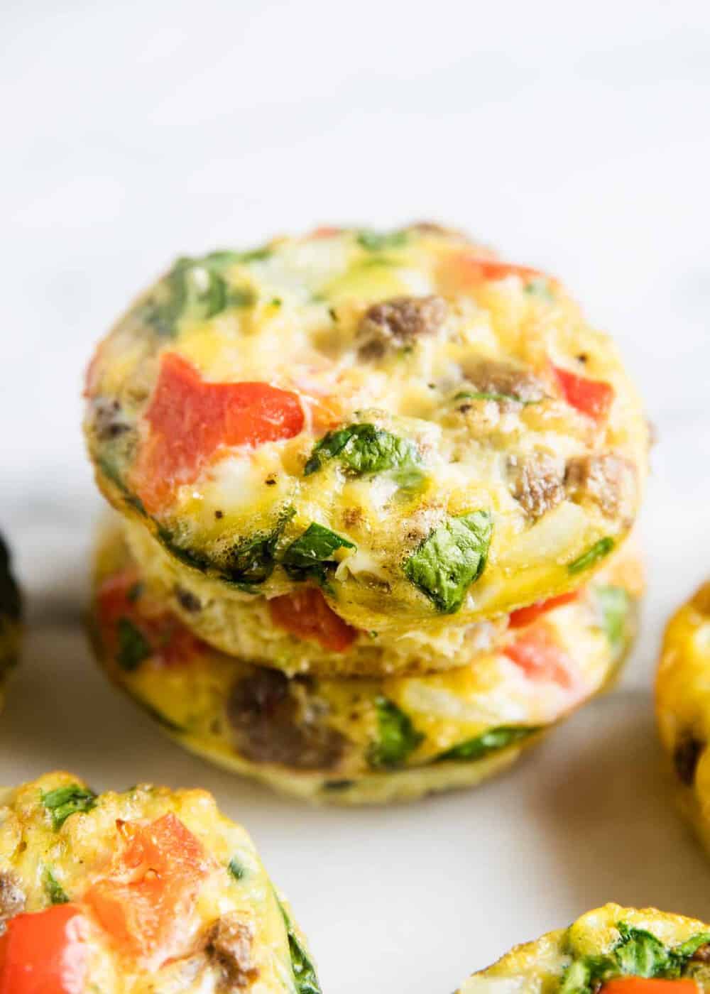 Frittata muffins stacked on white plate.