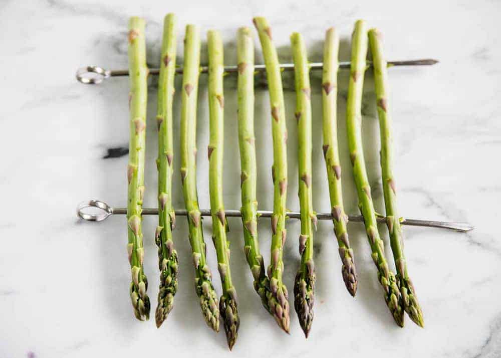 Raw asparagus on skewers.