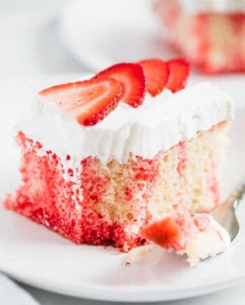 jello poke cake with whipped cream and strawberries