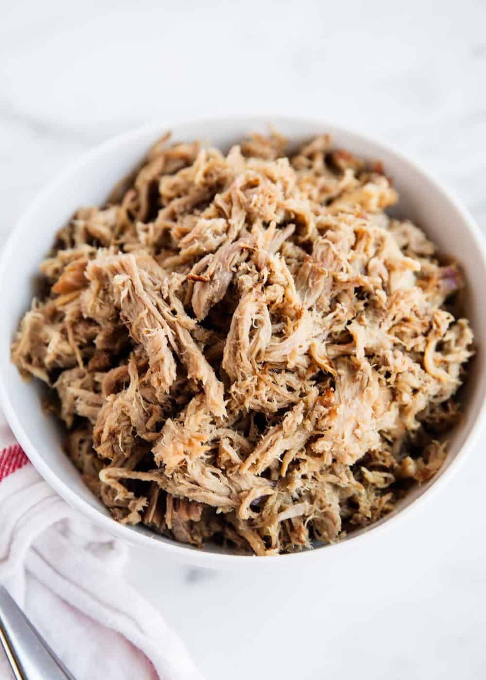 Shredded kalua pork in a white bowl.